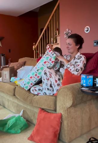 Mom opens Christmas gift from her son.