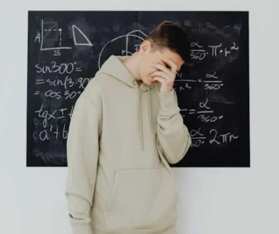 Boy covering his face after ansewring a complex math problem