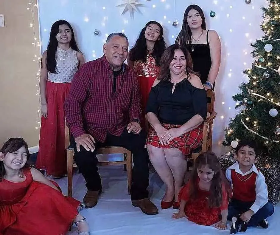 Juan, Rosa, their biological daughter and five adoptive kids posing for a Christmas family photo.