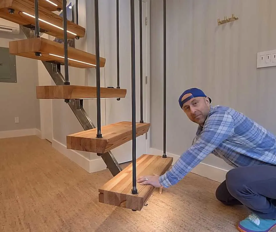 Nick, showing his eco-friendly home's unique staircase with lights under the steps.