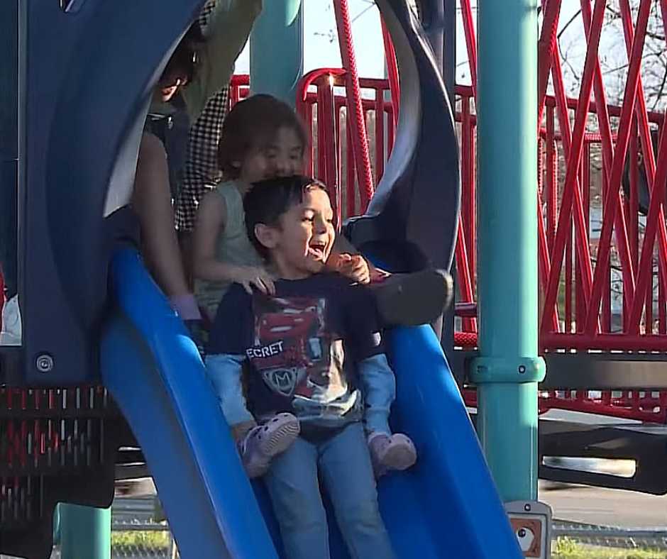The Navaez's adoptive kids enjoying the slide at the park.