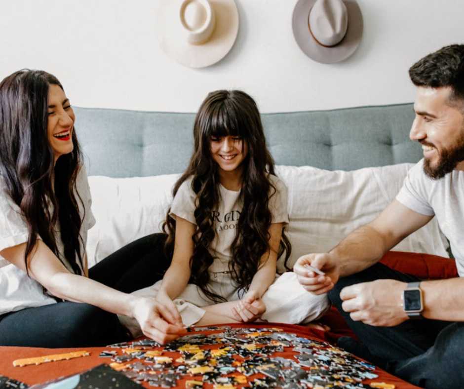 Family solving jigsaw puzzle together