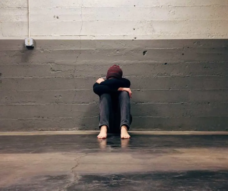 Sad person leaning on wall