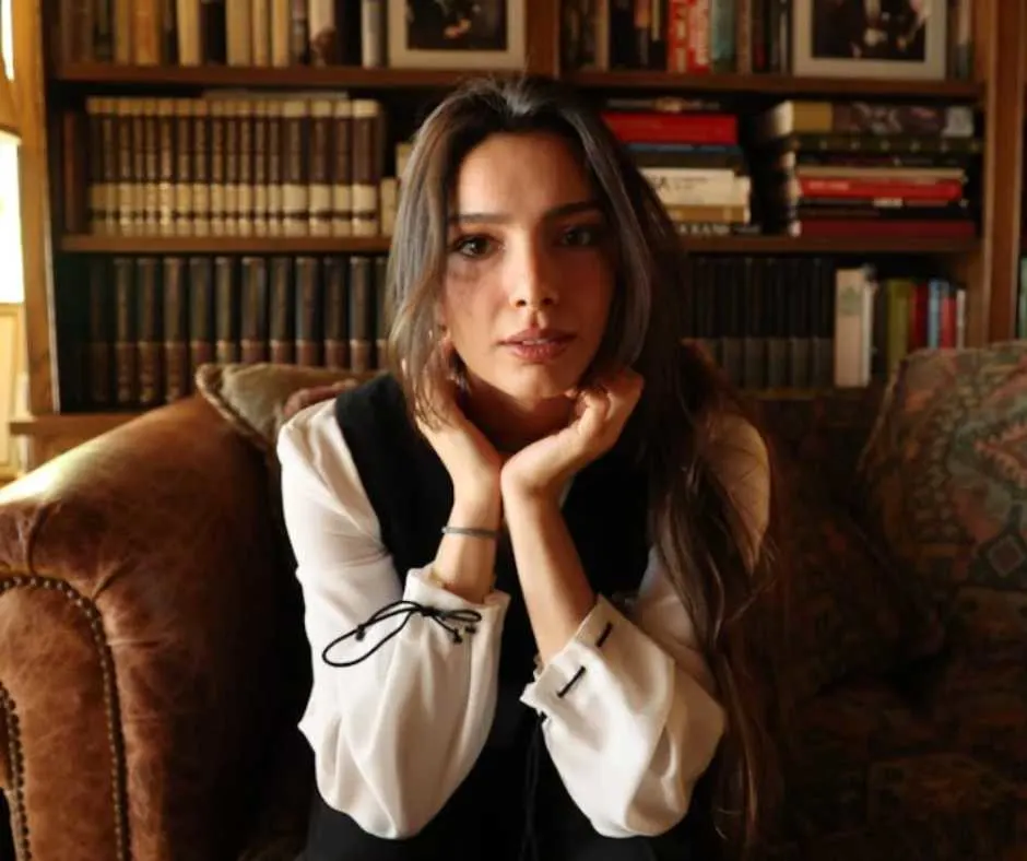 Woman sitting on a couch and touching her neck