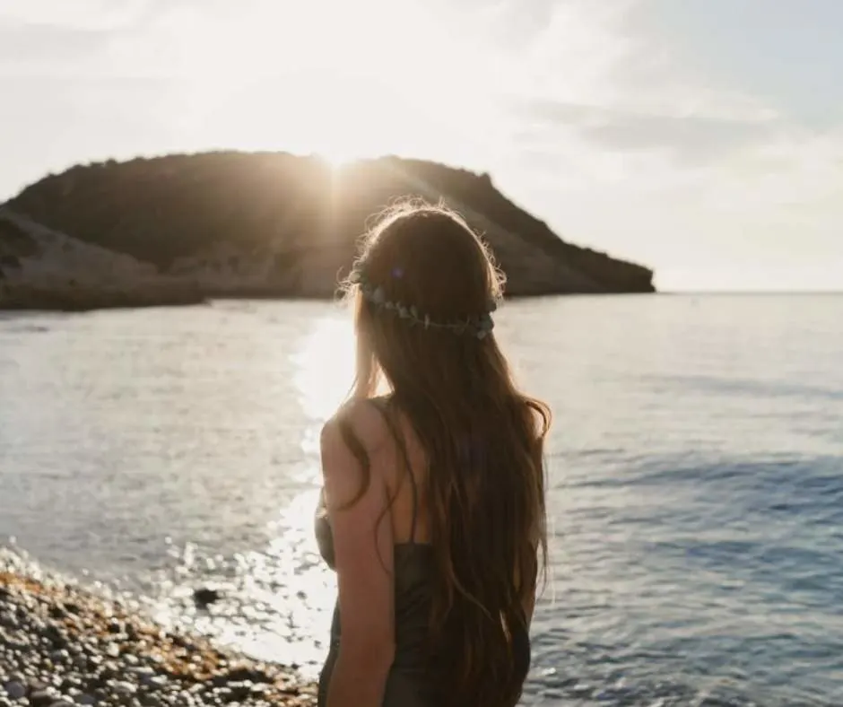 Woman enjoying the morning sun by the beach